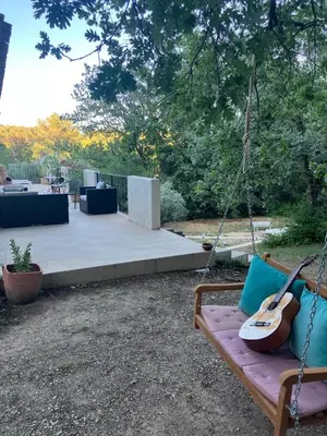a guitar hanging on a swing in a yard at Villa Paradis des Oréades in Lauris