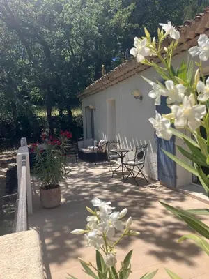 a patio with chairs and a house with flowers at Villa Paradis des Oréades in Lauris