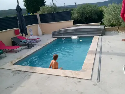 a man is sitting in a swimming pool at la bastide aux buis avec piscine in Blauvac