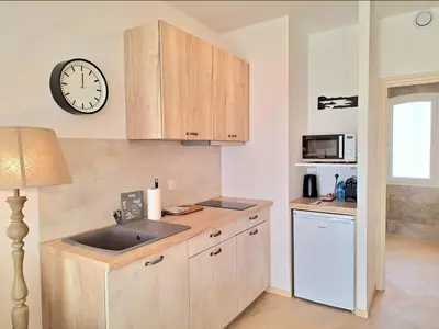 a kitchen with a sink and a clock on the wall at Domaine de la Mautanne in Sainte-Tulle