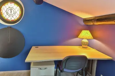 a desk with a lamp and a chair in a room at La Maison Bleue in LʼIsle-sur-la-Sorgue