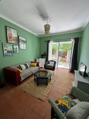 a living room with a couch and a table at Maison Jasmin in the city center with parking space and terrace in LʼIsle-sur-la-Sorgue