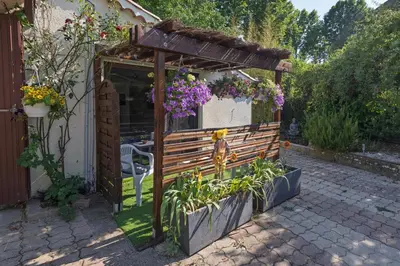 a wooden pergola with flowers in a garden at Studio dans le Luberon in Céreste