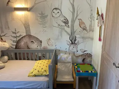 a childs bedroom with a woodland themed wall mural at appartement T3 golf in Mallemort
