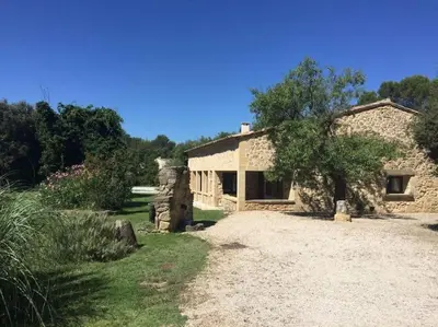 a stone house with a tree and a dirt road at Bergerie de charme proche Aix en Provence et Lubéron in Rognes
