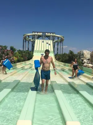 a man standing on a slide at a water park at Chambre chez habitant résidence piscine in Carpentras