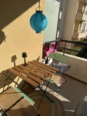 a wooden bench and a blue light hanging from a building at Chambre chez habitant résidence piscine in Carpentras