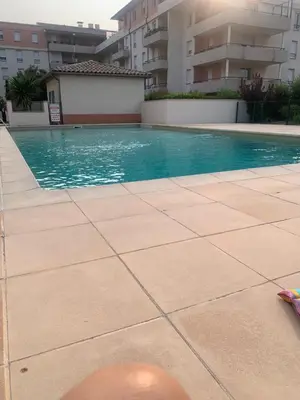 a swimming pool in the middle of a building at Chambre chez habitant résidence piscine in Carpentras
