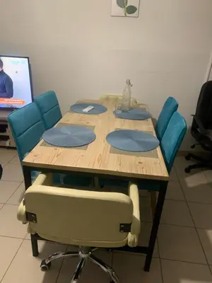a wooden table with blue chairs and a table with a cat on it at Chambre chez habitant résidence piscine in Carpentras
