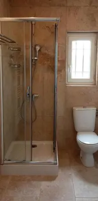 a bathroom with a shower with a toilet and a window at Maison face au Luberon avec piscine privée - 3 Chambres in Cabrières-dʼAvignon