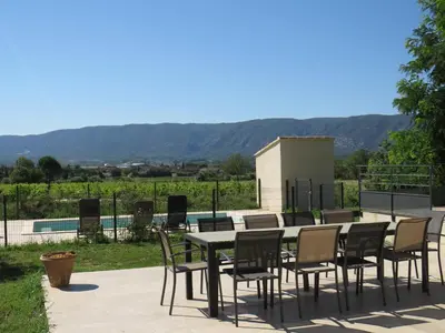 a table and chairs on a patio with a view at Maison face au Luberon avec piscine privée - 3 Chambres in Cabrières-dʼAvignon