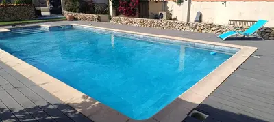 a blue swimming pool with a blue chair and a chair at Chez Lucho et carole in La Bastidonne