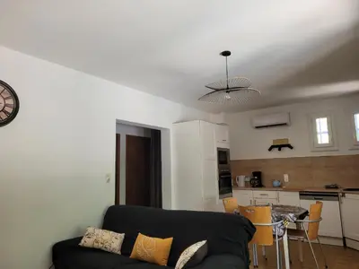 a living room with a couch and a kitchen at Borie en Provence in Velleron