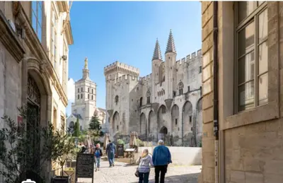 a group of people walking down a street in a castle at Borie en Provence in Velleron
