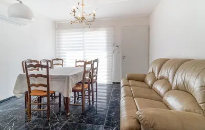 a dining room with a table and a couch at 2 Bedroom Nice Home In Chateaurenard in Châteaurenard