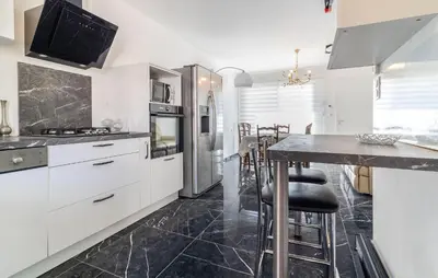 a kitchen with white cabinets and a black tile floor at 2 Bedroom Nice Home In Chateaurenard in Châteaurenard