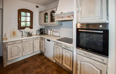 a large kitchen with wooden cabinets and appliances at Amazing Home In Beaumont-De-Pertuis in Beaumont-de-Pertuis