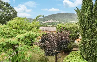 a garden with trees and a house in the background at Amazing Home In Beaumont-De-Pertuis in Beaumont-de-Pertuis