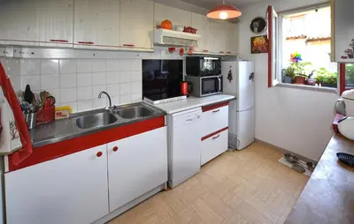 a kitchen with white cabinets and a sink and a refrigerator at Nice Apartment In L'isle-Sur-La-Sorgue in LʼIsle-sur-la-Sorgue