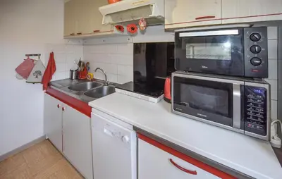 a small kitchen with a microwave and a sink at Nice Apartment In L'isle-Sur-La-Sorgue in LʼIsle-sur-la-Sorgue