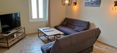 a living room with a couch and a television at Camargu'Alpilles in Mollégès