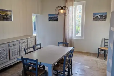 a dining room with a white table and chairs at Camargu'Alpilles in Mollégès