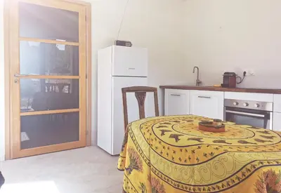 a kitchen with a table with a yellow blanket on it at Logement au calme à LOURMARIN in Lourmarin