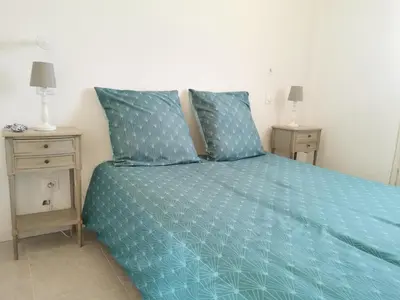a bedroom with a blue bed with two night stands at Logement au calme à LOURMARIN in Lourmarin