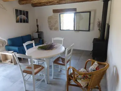 a living room with a white table and chairs at Le grangeon des Hermas in Sault-de-Vaucluse