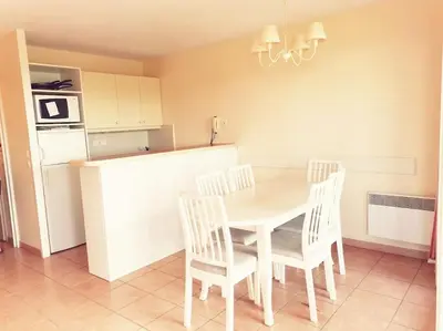 a kitchen with a table and chairs and a refrigerator at Petit cocon en Provence in Mallemort