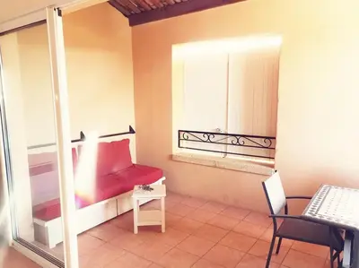 a room with a red bed and a window at Petit cocon en Provence in Mallemort
