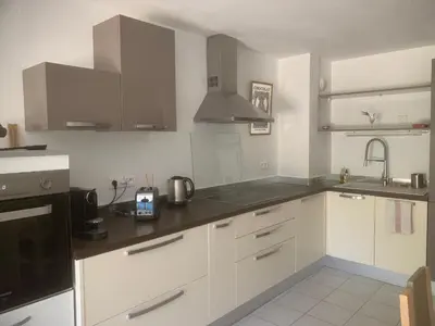 a kitchen with white cabinets and stainless steel appliances at Appartement, 1 chambre, jardin privatif in Venelles