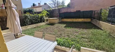 a small backyard with a white table and chairs at Appartement, 1 chambre, jardin privatif in Venelles