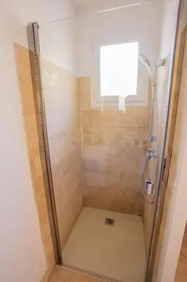 a shower with a glass door in a bathroom at Maison avec jardin in Saumane-de-Vaucluse