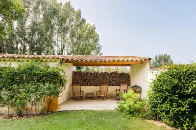 a house with a patio with chairs and trees at Beautiful Provencal Mas with swimming pool in Le Thor