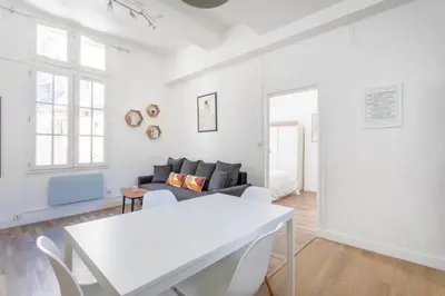 a white living room with a white table and a couch at T2 lumineux plein centre à 5 min du Cours Mirabeau confort, wifi, cuisine équipée in Aix-en-Provence