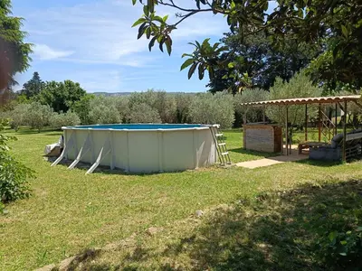 a large trampoline in a yard with a gazebo at Véritable maison de campagne nouvellement rénovée au pied du Lubéron in Cheval-Blanc