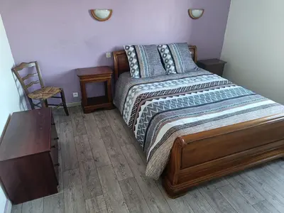 a bedroom with a bed and a table and a chair at Véritable maison de campagne nouvellement rénovée au pied du Lubéron in Cheval-Blanc