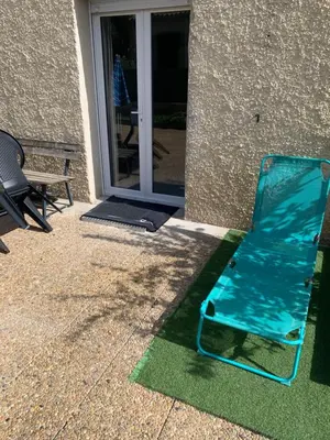 a blue lawn chair sitting in front of a door at Suite avec sauna in Pertuis