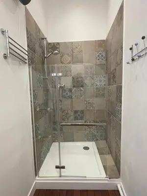 a shower with a glass door in a bathroom at Studio cosy climatisé au coeur du village de Saint Michel l'Observatoire in Saint-Michel-lʼObservatoire