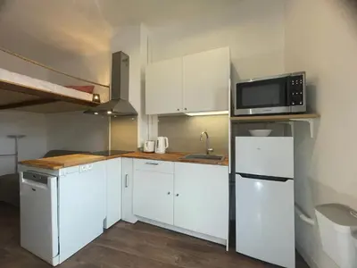a small kitchen with white cabinets and a microwave at Studio cosy climatisé au coeur du village de Saint Michel l'Observatoire in Saint-Michel-lʼObservatoire