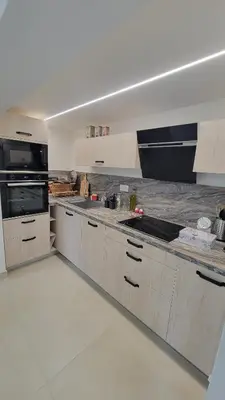 a kitchen with white cabinets and a counter top at Le PEROTIN in Villes-sur-Auzon