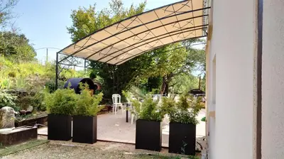 an arbor with potted plants in a garden at Le PEROTIN in Villes-sur-Auzon