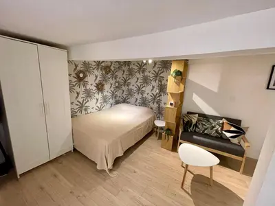 a small bedroom with a bed and a chair at Studio Tout confort Centre historique rue calme Climatisation in Aix-en-Provence