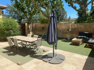 a patio with a table and an umbrella at Appartement de standing dans une bastide Aixoise in Aix-en-Provence