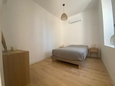 a bedroom with a bed and a wooden floor at Appartement de standing dans une bastide Aixoise in Aix-en-Provence