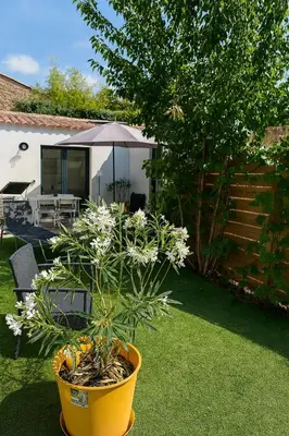 a large yellow pot with a plant in a yard at Maison moderne jardin piscine et parking prives, près d'Aix Centre in Venelles