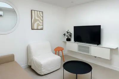 a living room with a tv and a chair at Maison moderne jardin piscine et parking prives, près d'Aix Centre in Venelles