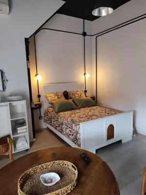 a bedroom with a bed in a room with a table at Les Oliviers in Caumont-sur-Durance