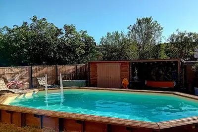 a swimming pool with a fountain in a backyard at Les Oliviers in Caumont-sur-Durance